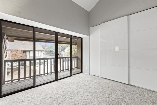 interior space featuring carpet floors and vaulted ceiling