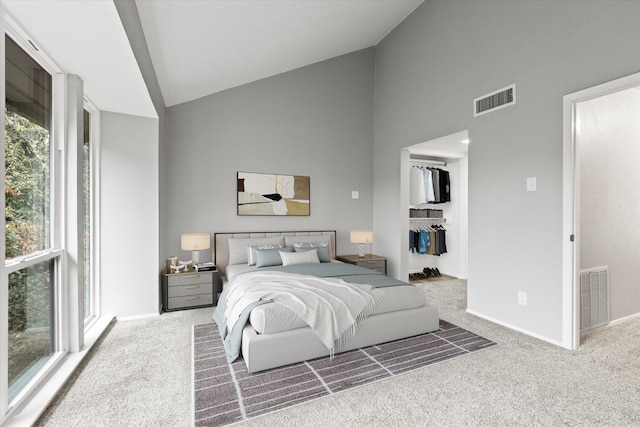 carpeted bedroom with high vaulted ceiling