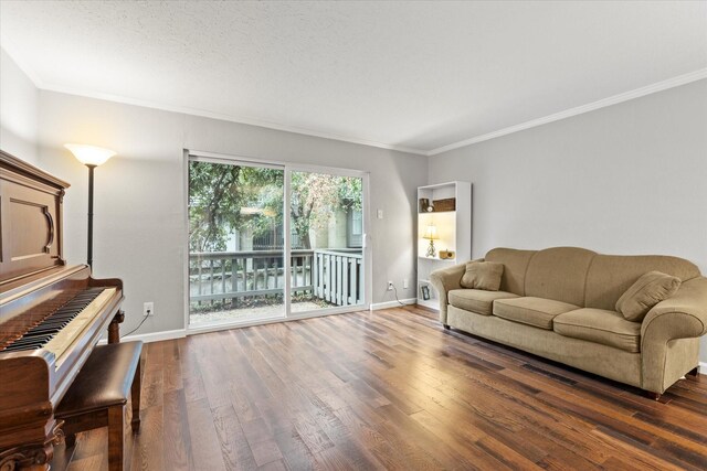 living room with dark hardwood / wood-style flooring, a textured ceiling, and ornamental molding