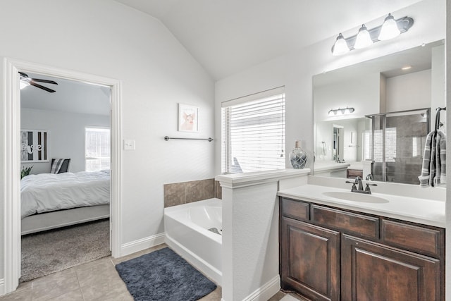 bathroom with tile patterned flooring, vanity, vaulted ceiling, and a healthy amount of sunlight