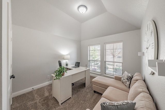 office with dark colored carpet and lofted ceiling