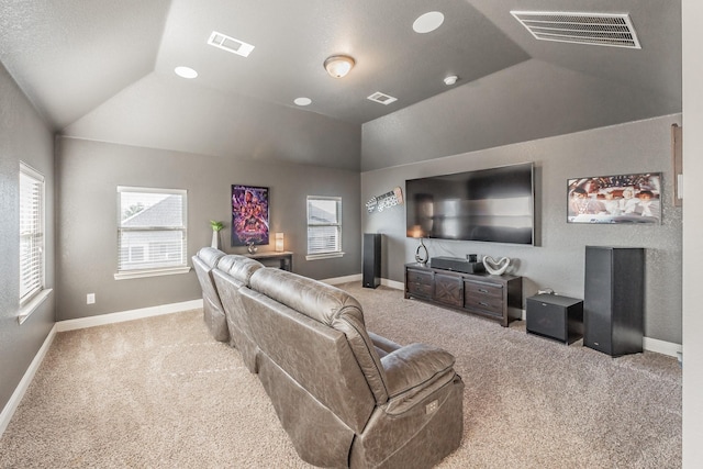 carpeted cinema room with lofted ceiling and a healthy amount of sunlight