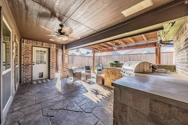 view of patio / terrace with ceiling fan, an outdoor kitchen, and a grill