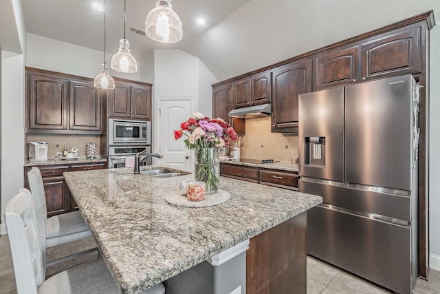 kitchen featuring stainless steel appliances, an island with sink, and dark brown cabinets