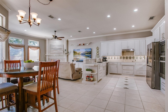 kitchen with kitchen peninsula, backsplash, ceiling fan with notable chandelier, decorative light fixtures, and white cabinetry