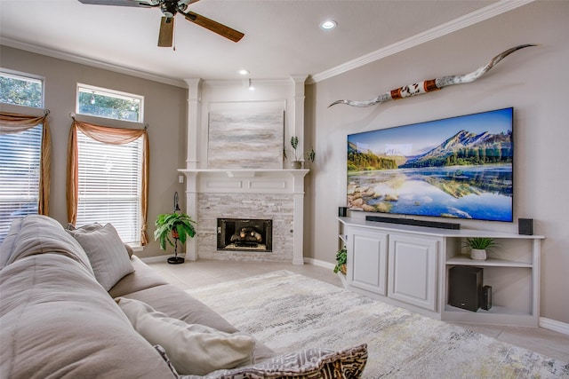 tiled living room with a stone fireplace, crown molding, and ceiling fan