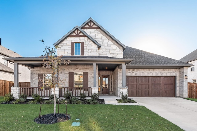 view of front of house with a front yard, a porch, and a garage