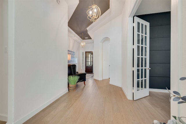 hallway featuring an inviting chandelier and hardwood / wood-style flooring