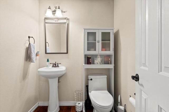 bathroom with sink, toilet, and hardwood / wood-style floors