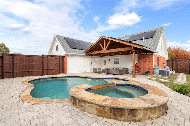 view of swimming pool with an outdoor living space, an in ground hot tub, and a patio area