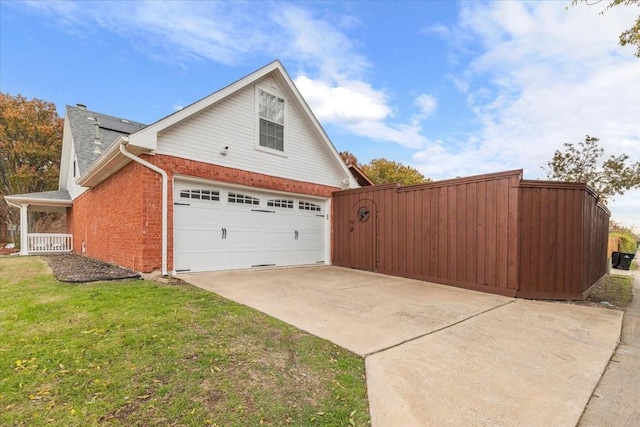 view of side of home featuring a garage and a lawn