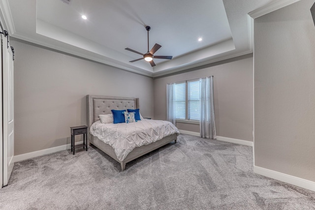 carpeted bedroom featuring a raised ceiling, ceiling fan, and ornamental molding