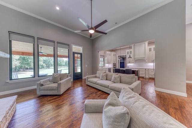 living room featuring dark wood-type flooring, crown molding, and a healthy amount of sunlight