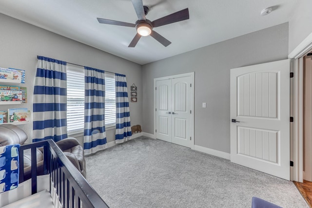 carpeted bedroom featuring ceiling fan and a closet