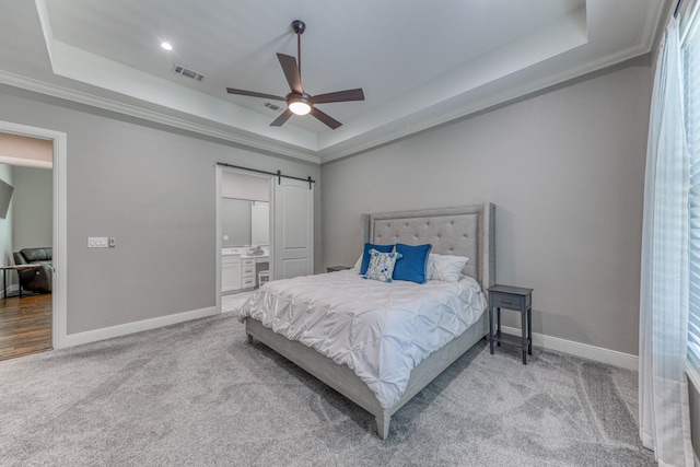 bedroom with a barn door, a raised ceiling, ceiling fan, and crown molding