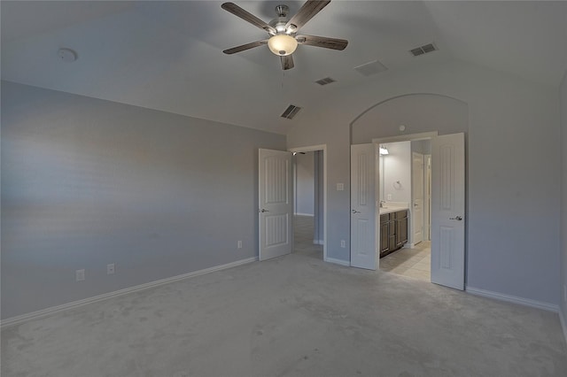 unfurnished bedroom with light carpet, lofted ceiling, ceiling fan, and ensuite bath