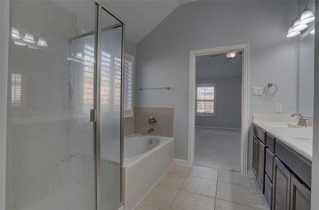 bathroom with tile patterned flooring, vaulted ceiling, vanity, and shower with separate bathtub