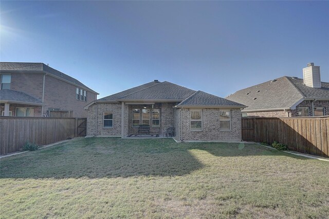 rear view of house with a yard