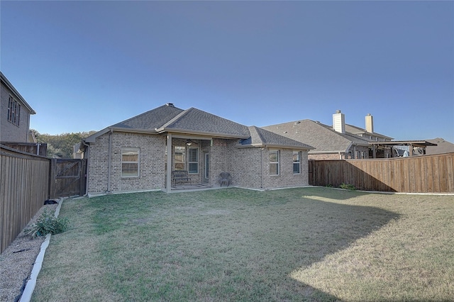 rear view of house featuring a yard