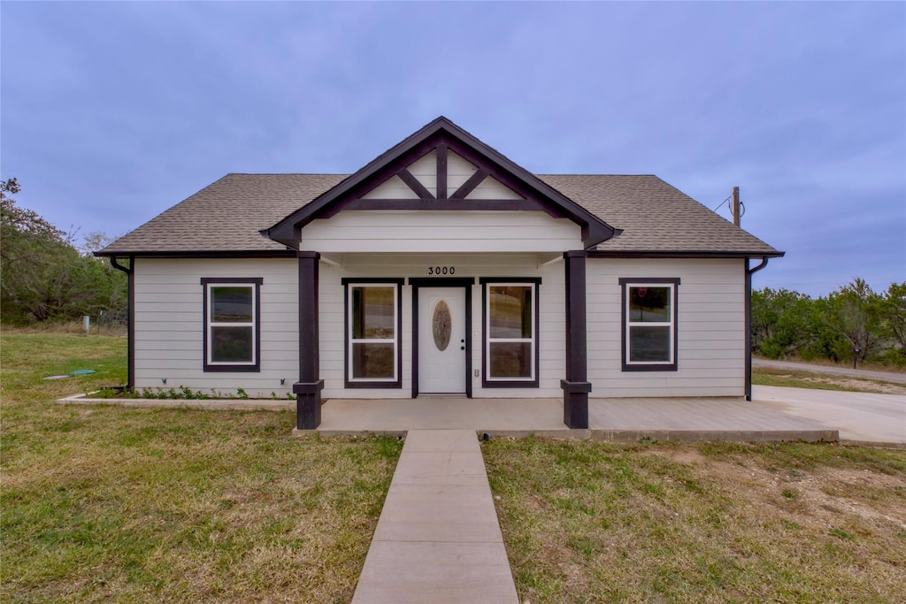 bungalow-style home featuring a porch and a front yard