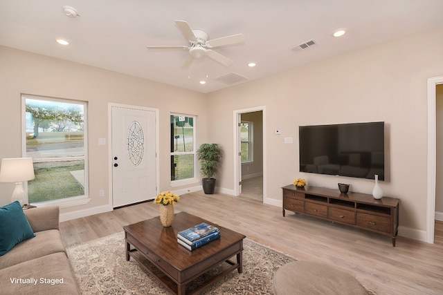 living room with ceiling fan and light hardwood / wood-style flooring