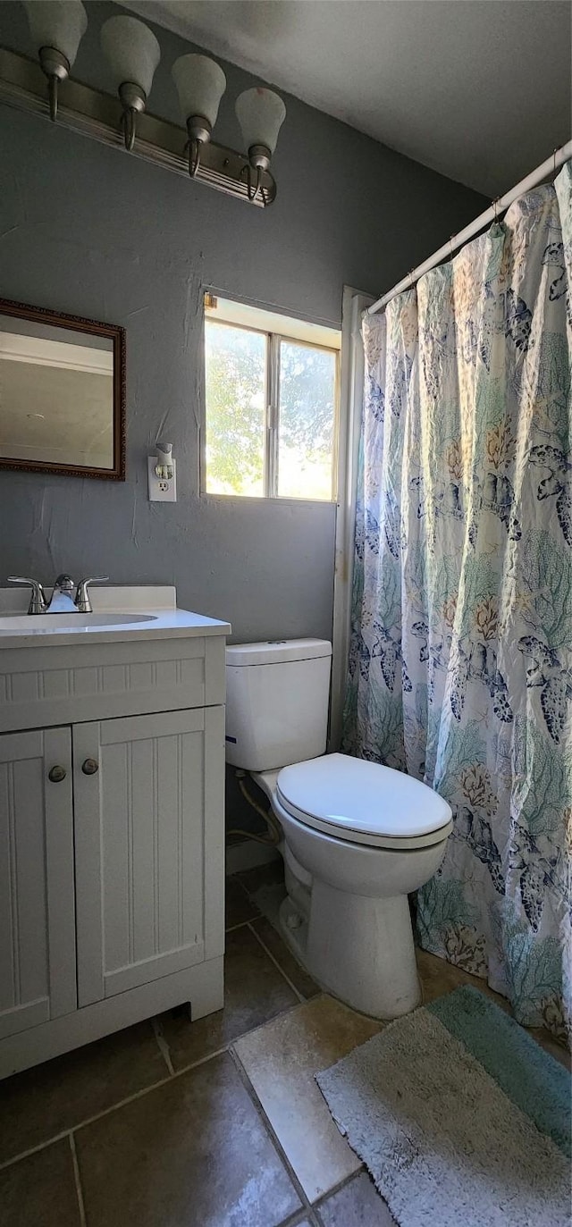 bathroom with tile patterned flooring, vanity, and toilet