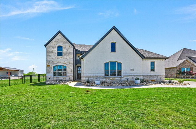 french country style house featuring a front yard