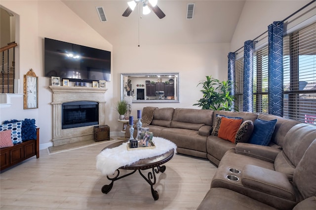 living room featuring ceiling fan, vaulted ceiling, and light wood-type flooring