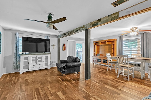 living room featuring wood-type flooring, ceiling fan, and plenty of natural light