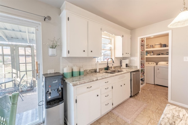 kitchen featuring sink, hanging light fixtures, independent washer and dryer, decorative backsplash, and white cabinets