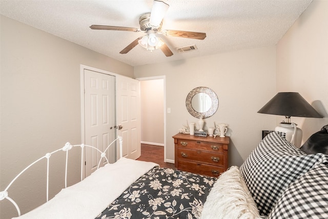 bedroom with ceiling fan, a closet, and a textured ceiling