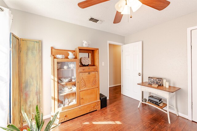 interior space with hardwood / wood-style floors, ceiling fan, and a textured ceiling