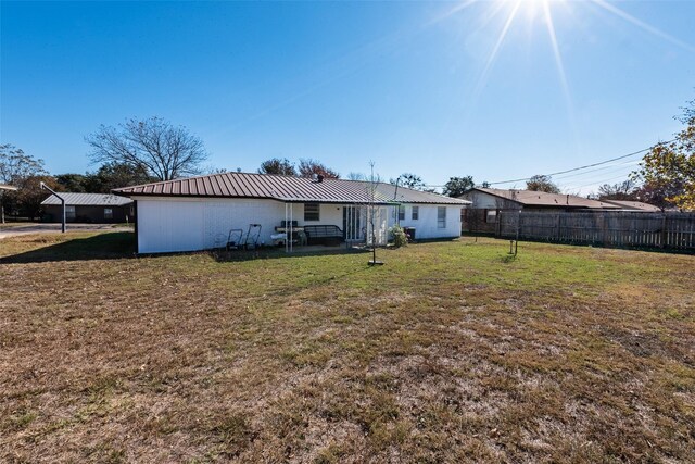 rear view of house featuring a lawn