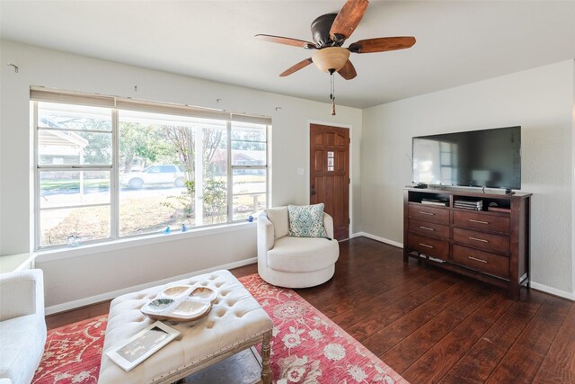 living room featuring ceiling fan and dark wood-type flooring