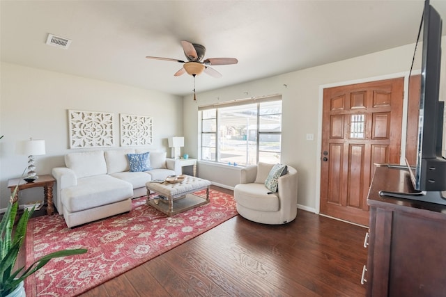 living room featuring ceiling fan and dark wood-type flooring