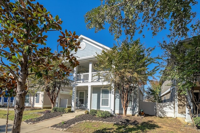 view of front of house featuring ceiling fan and a balcony