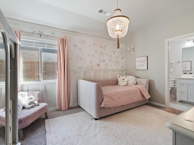 bedroom featuring an inviting chandelier, ensuite bath, and light carpet