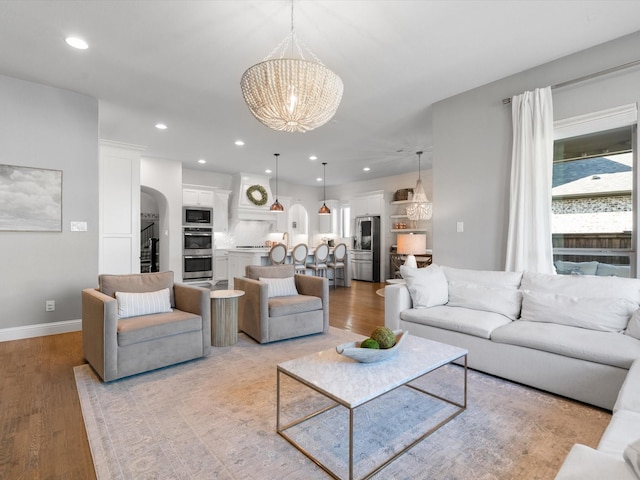 living room featuring an inviting chandelier and light hardwood / wood-style flooring