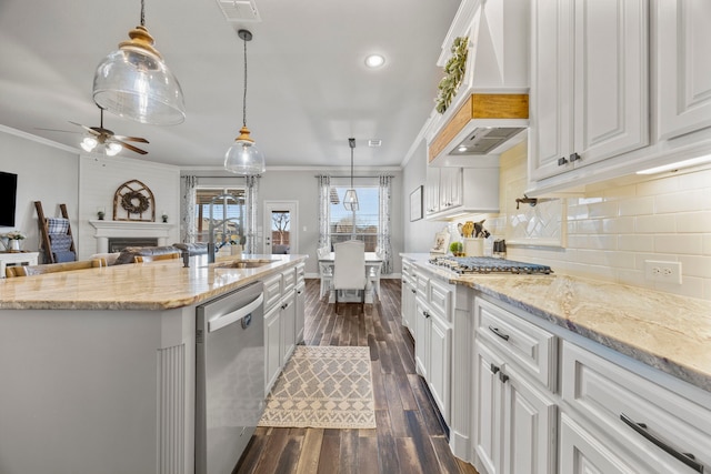 kitchen featuring a large fireplace, appliances with stainless steel finishes, sink, and white cabinets