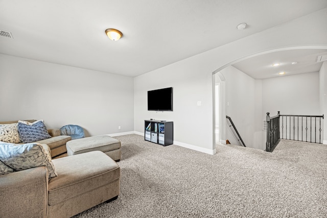 living room with visible vents, baseboards, arched walkways, and carpet floors