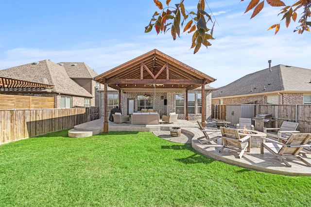 back of property featuring a fenced backyard, a lawn, an outdoor living space with a fire pit, and a patio