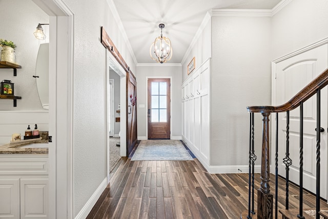 foyer entrance with stairway, baseboards, an inviting chandelier, dark wood-style flooring, and crown molding