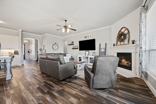 living area with arched walkways, a fireplace, dark wood-type flooring, and ceiling fan