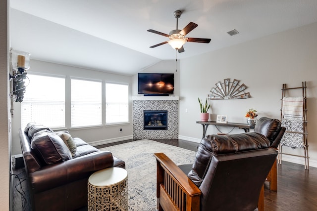 living room with dark hardwood / wood-style floors, ceiling fan, a fireplace, and vaulted ceiling