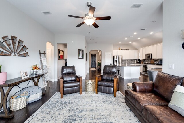 living room with ceiling fan, hardwood / wood-style floors, vaulted ceiling, and sink