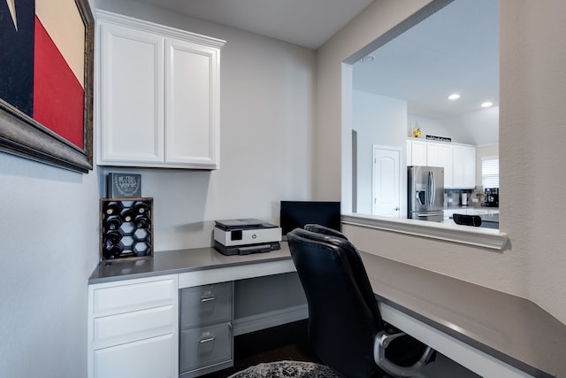 office space with built in desk and vaulted ceiling