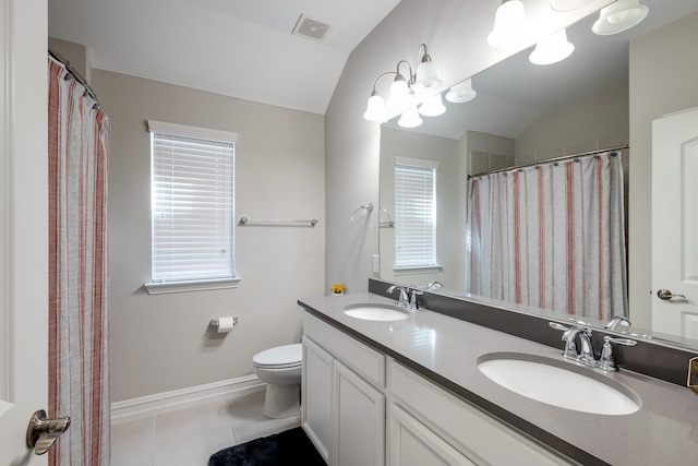 bathroom featuring tile patterned floors, vanity, a healthy amount of sunlight, and lofted ceiling