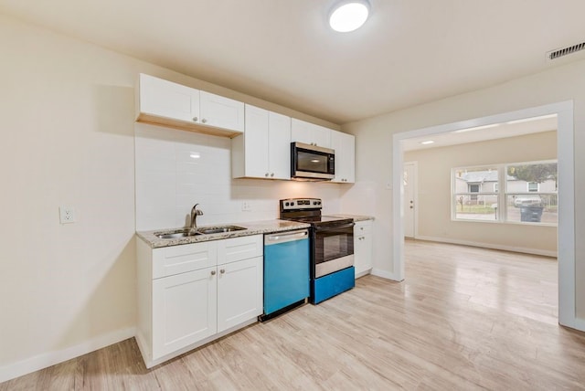 2233 Eastover Ave, Fort Worth, TX 76105 - kitchen featuring stainless steel appliances, white cabinetry, tasteful backsplash, light wood-type flooring, and light stone countertops