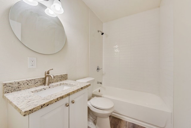 full bathroom featuring vanity, tiled shower / bath combo, hardwood / wood-style flooring, and toilet