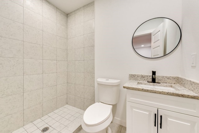 bathroom featuring tiled shower, vanity, and toilet